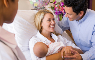 Man and woman holding baby in hospital bed