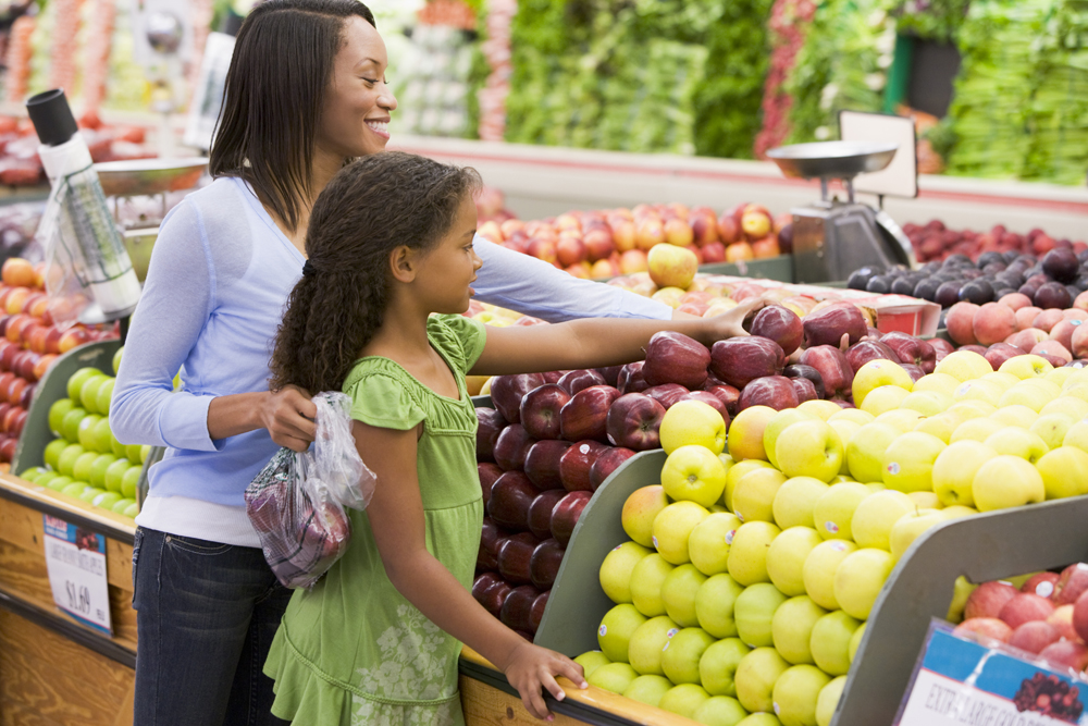 Mother and daughter selecting healthy fruit in produce section