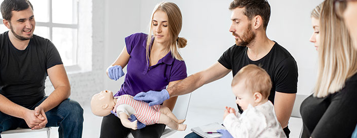 People learning about Infant CPR with a doll