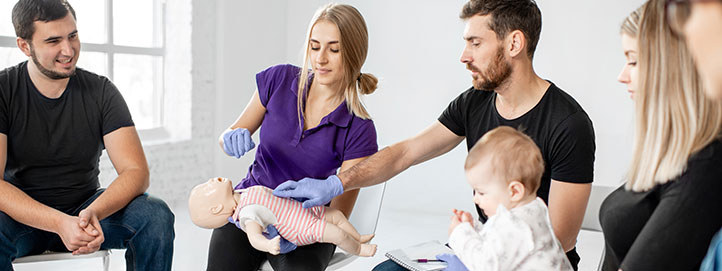 People learning about Infant CPR with a doll