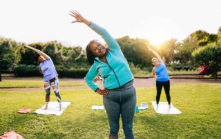 Senior women exercising during yoga workout at outdoors city park.