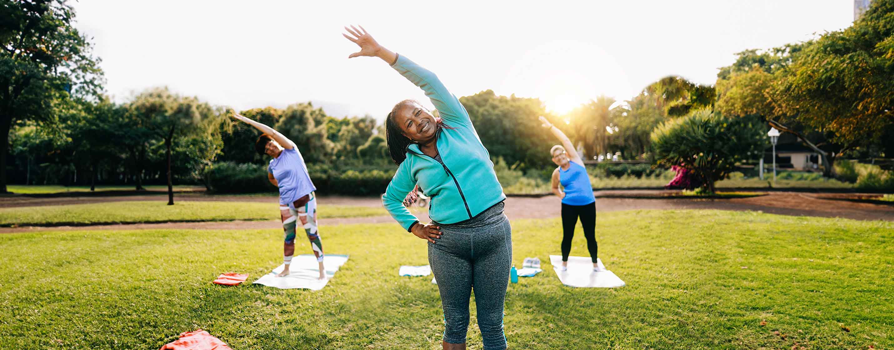 Senior women exercising during yoga workout at outdoors city park.
