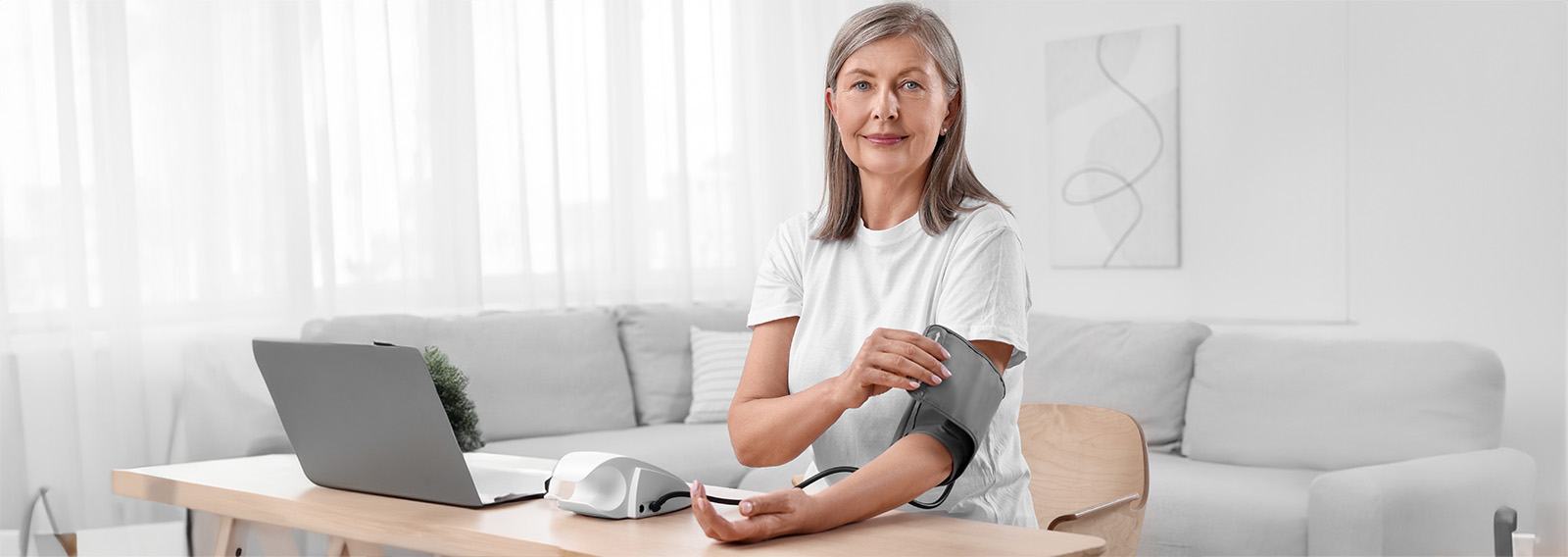 Senior woman tests blood pressure at home.